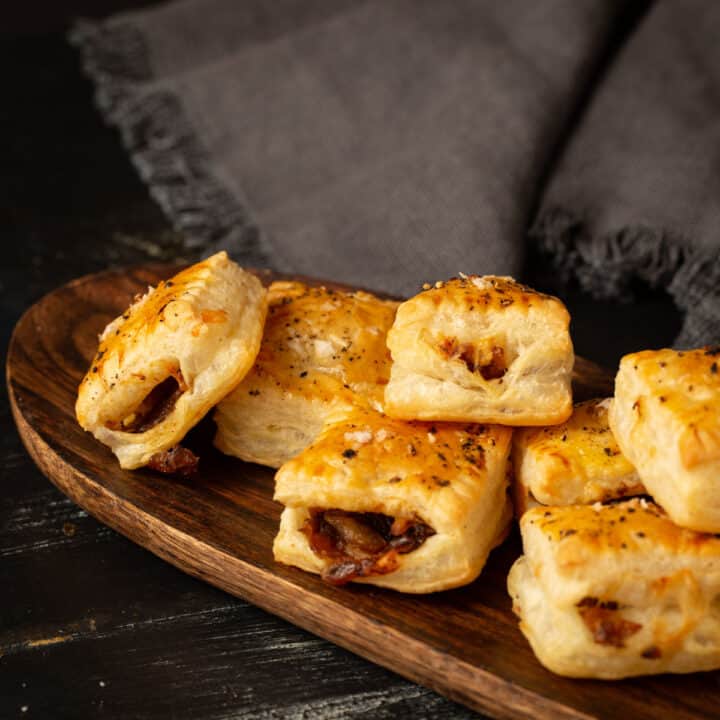 Puff pastry with caramelized onions on a wooden tray.