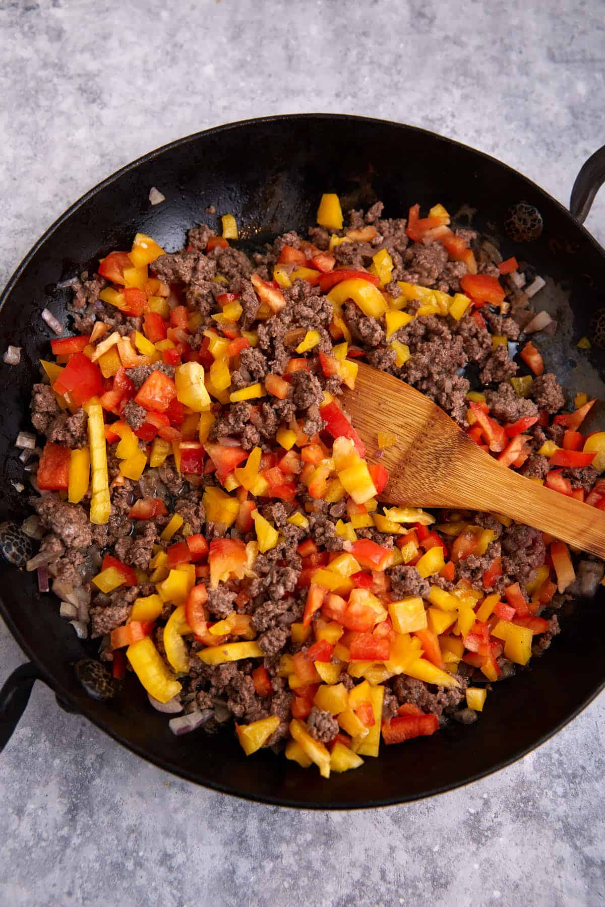 Ground beef and peppers in a skillet.