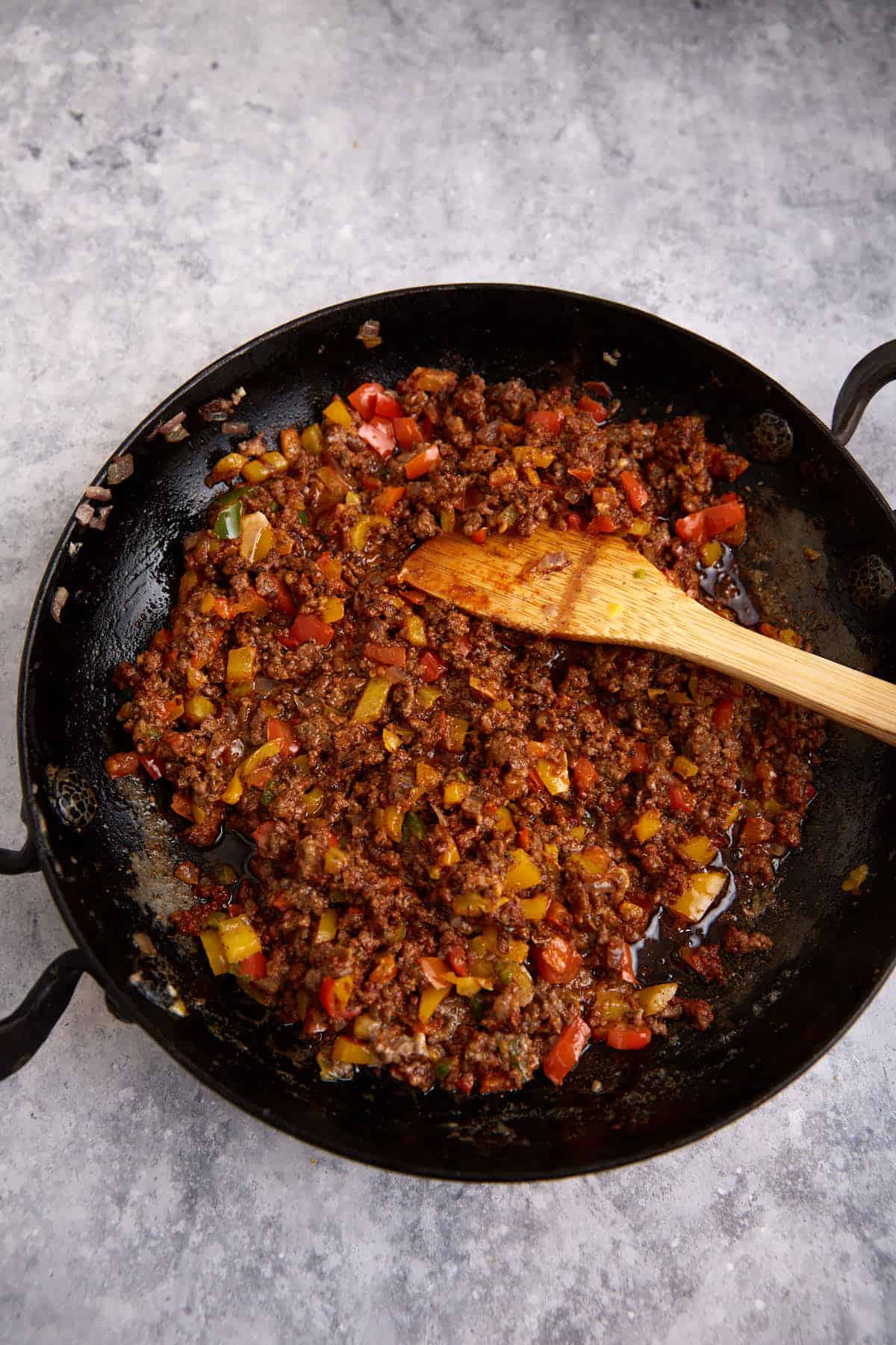 Cooked beef and peppers in a skillet.