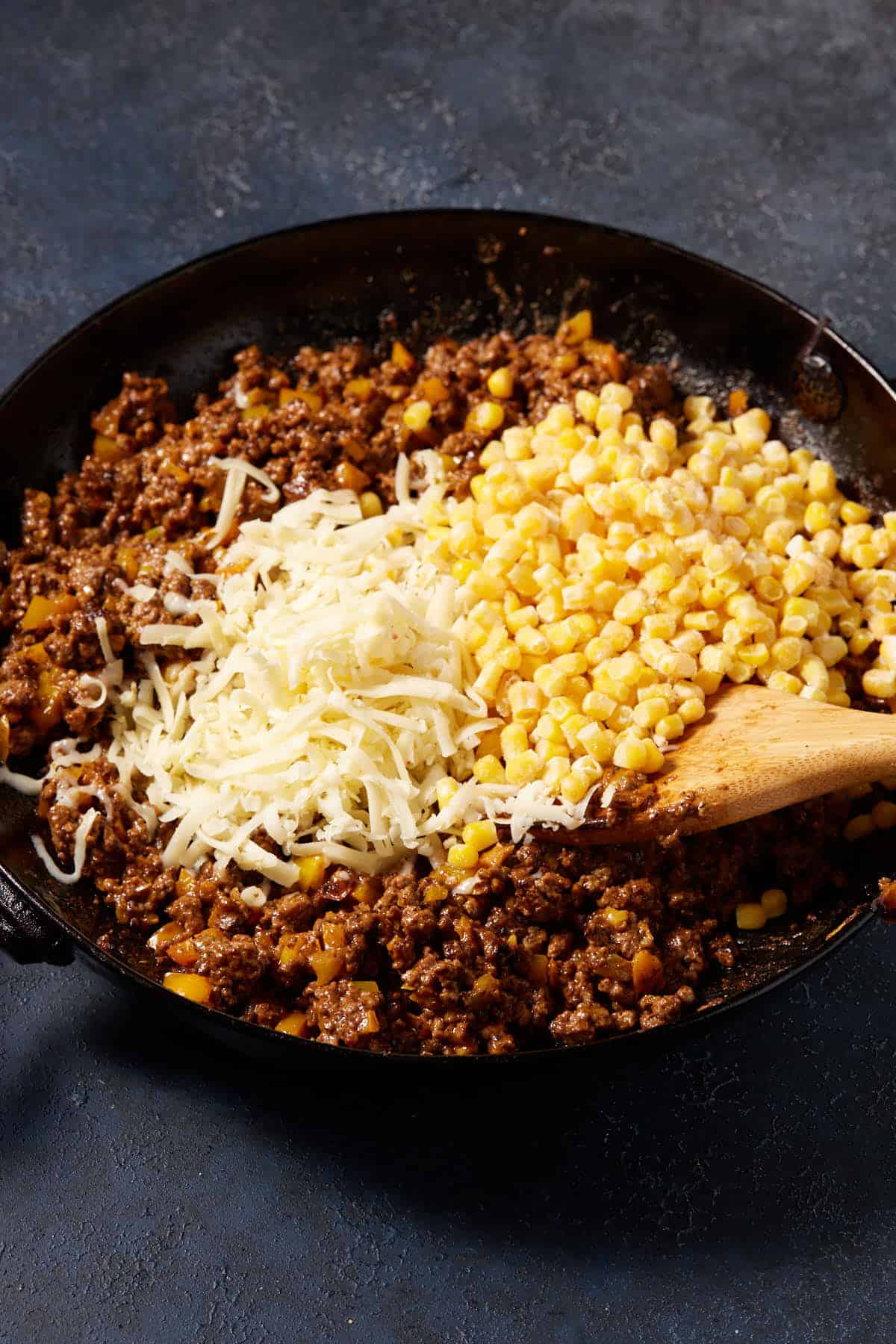 Cheese and corn in a skillet with hamburger filling.