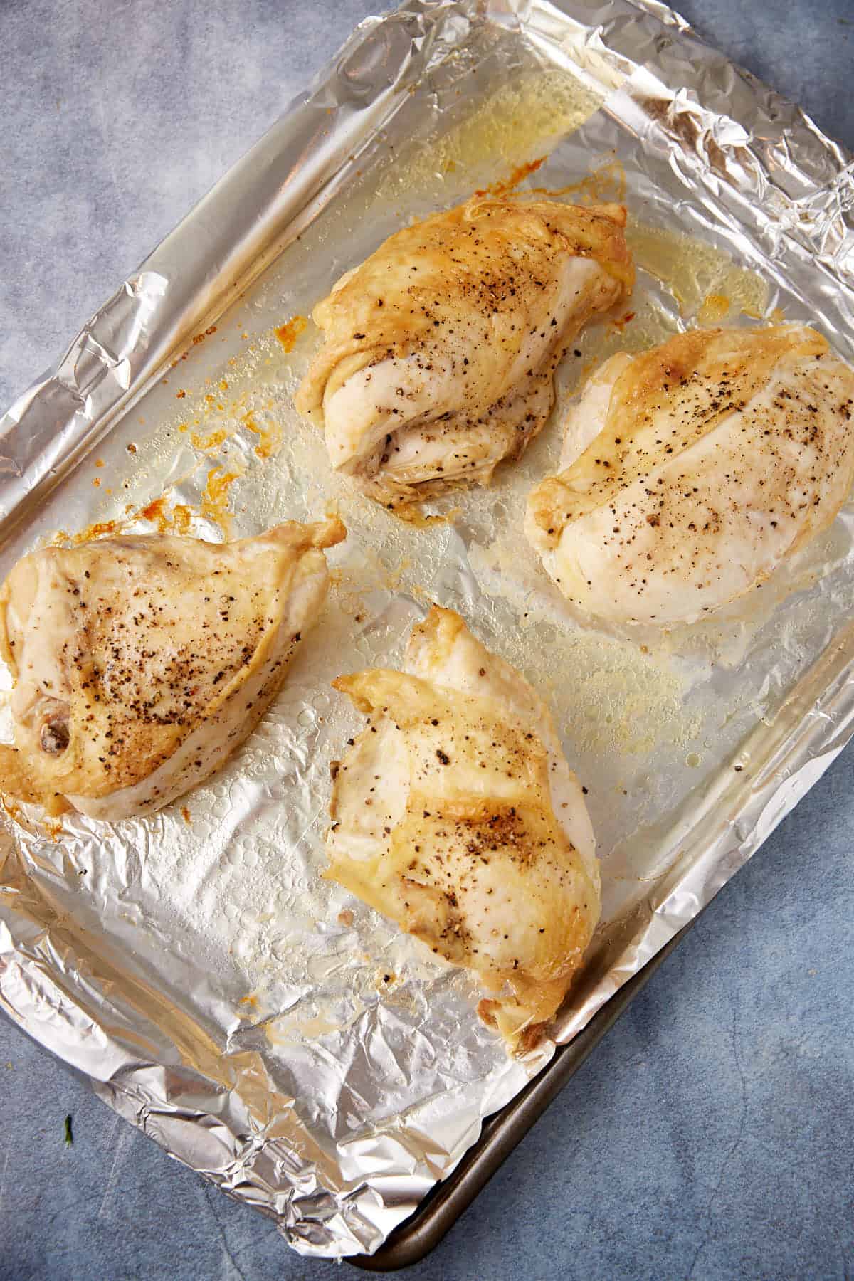 Chicken breasts roasted on a baking pan.