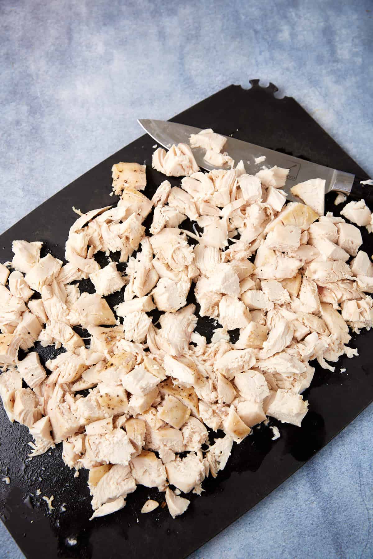 Chicken chopped on a cutting board.