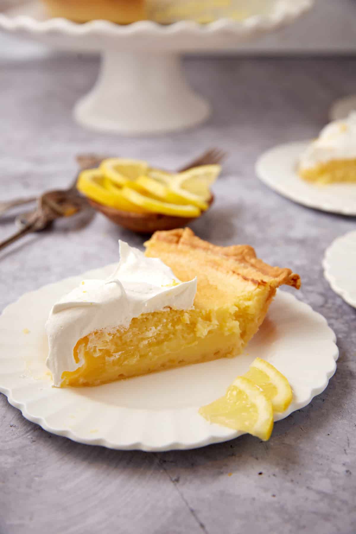 A slice of lemon chess pie with whipped cream on top.