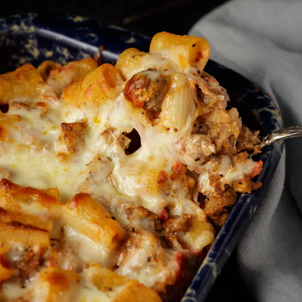 A baked penne alla vodka with a serving spoon.
