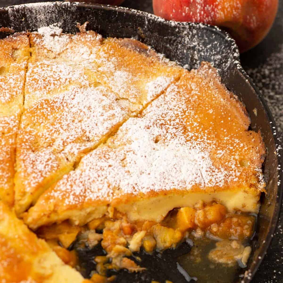 Slices of a peach Dutch baby pancake in an iron skillet.