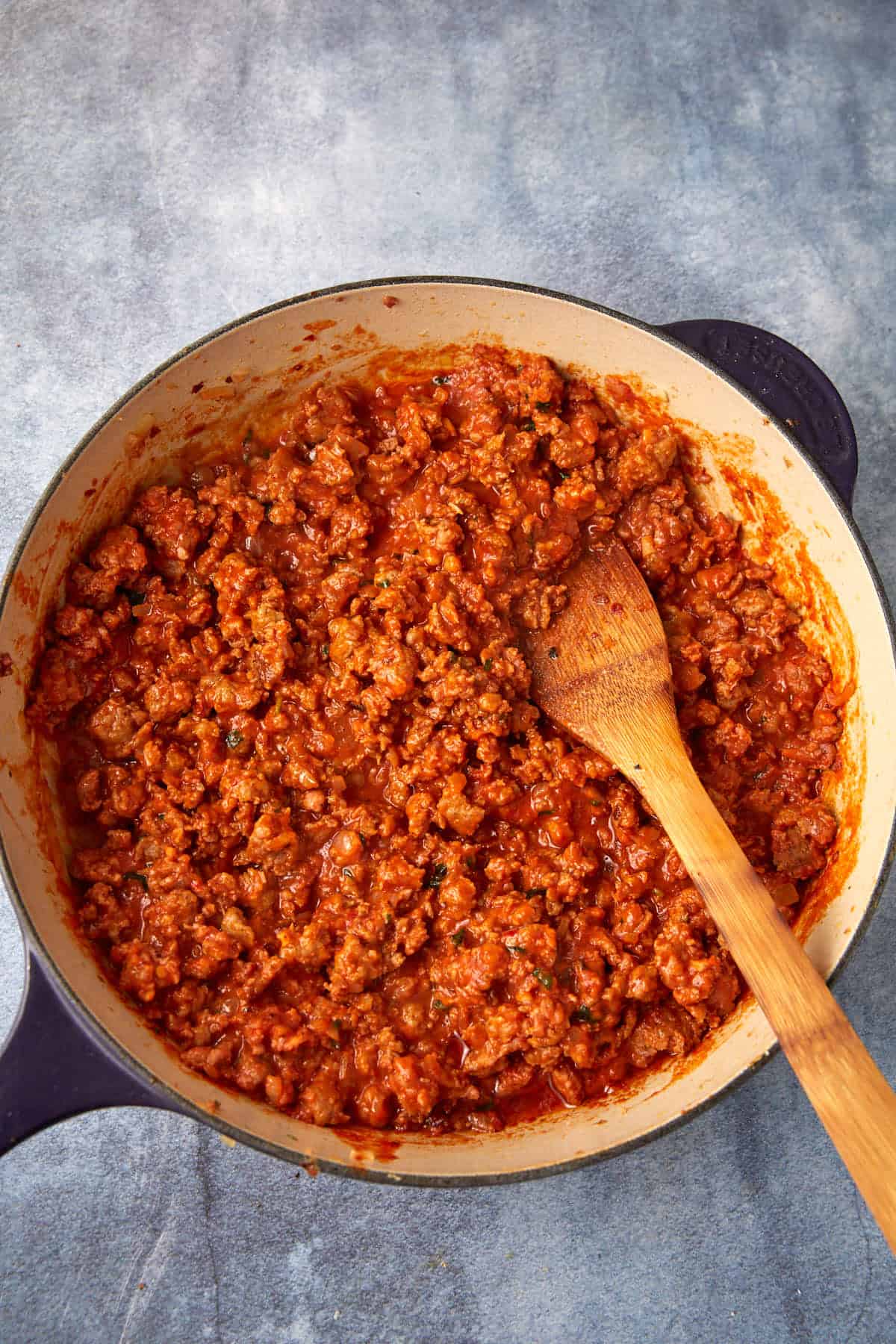 Cooked Italian sausage with vodka sauce in a skillet.