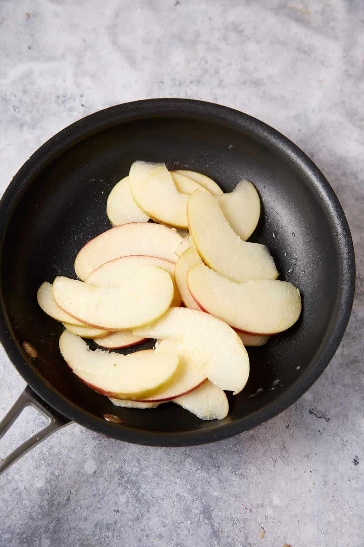 Sliced apples in a skillet.