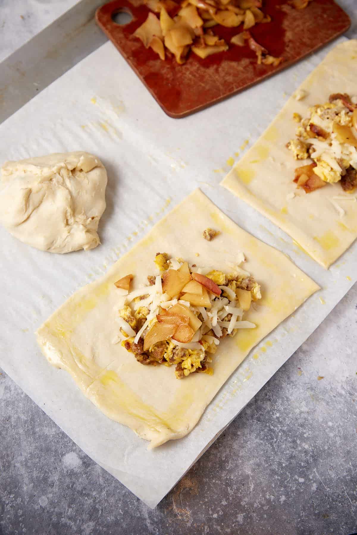 The sausage filling in the middle of a square of puff pastry.
