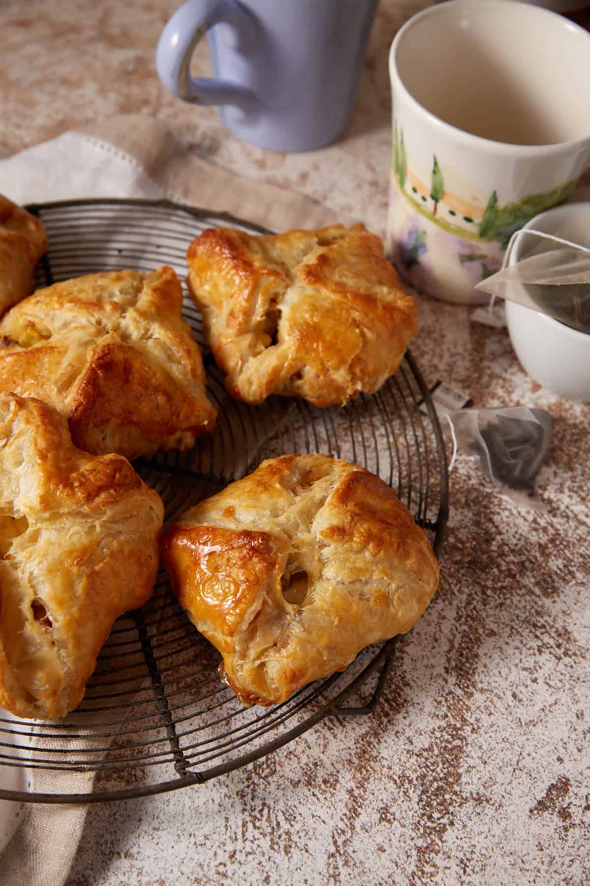 Puff pastry pockets next to mugs and tea bags.