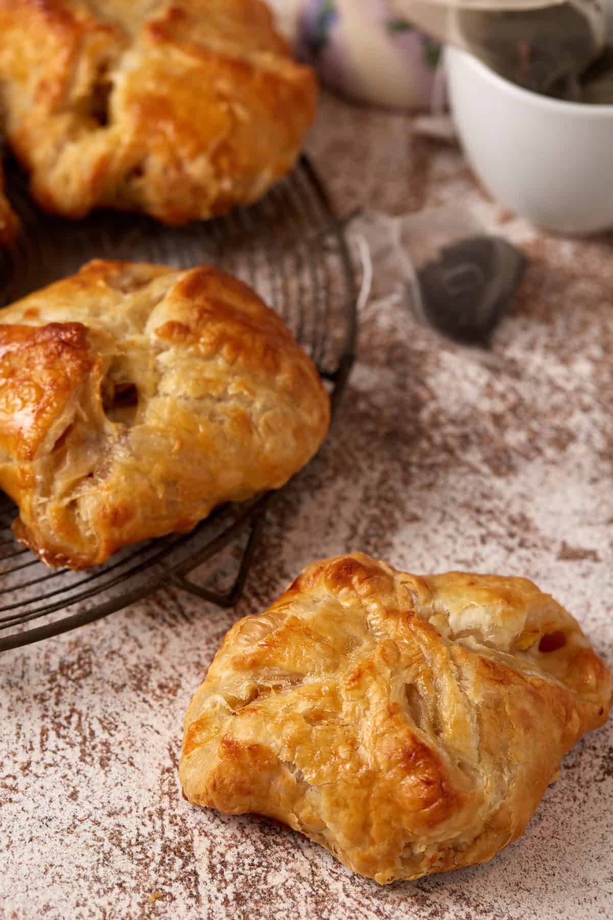 three puff pastry pockets next to tea bags.