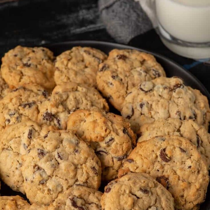 A plate of peanut butter oatmeal cookies with a glass of milk