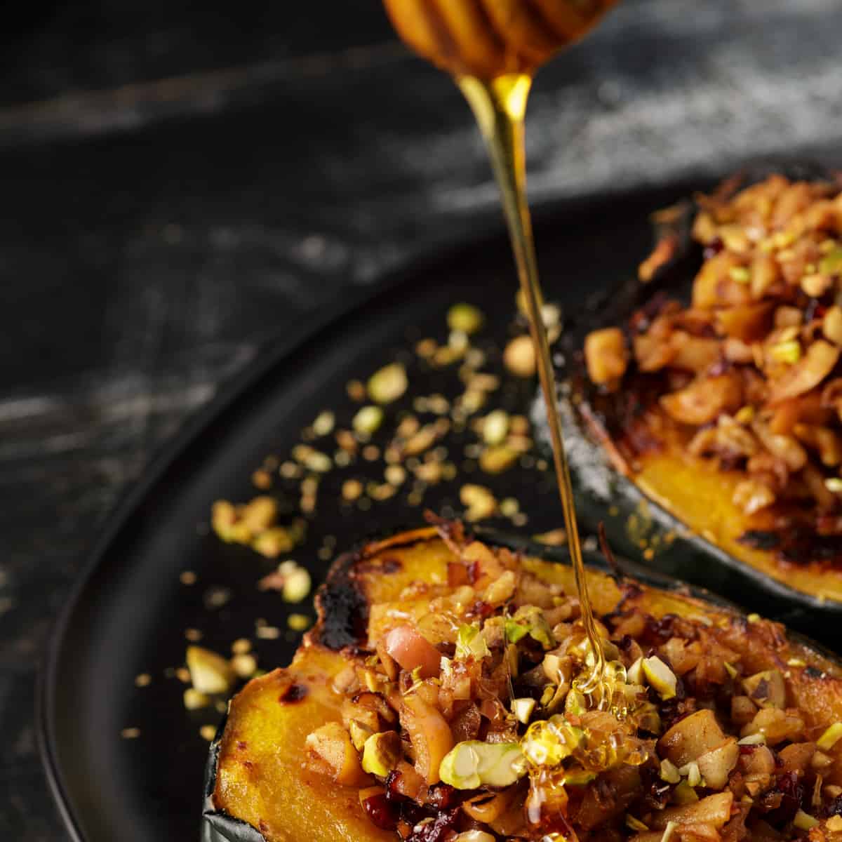 Honey being drizzled over stuffed acorn squash