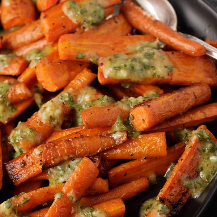 A platter of roasted carrots with vinaigrette.