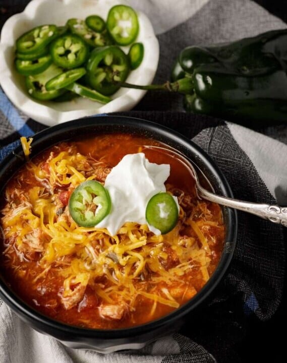 A bowl of chicken chili jalapeno slices