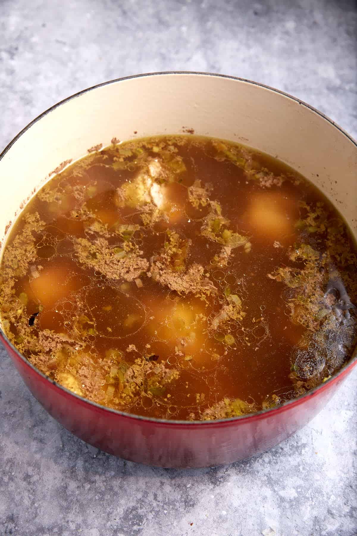 A pot of chicken cooked in broth.