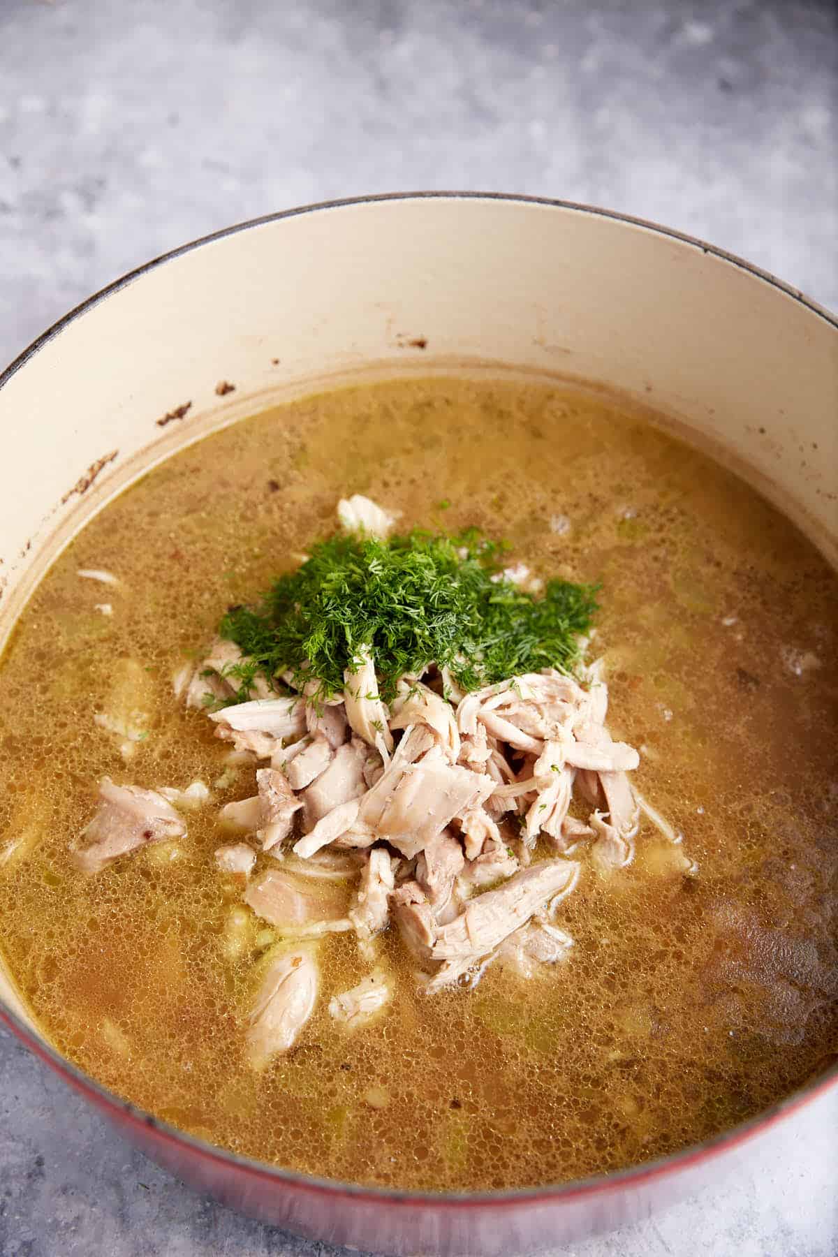 Chicken added to broth with orzo.