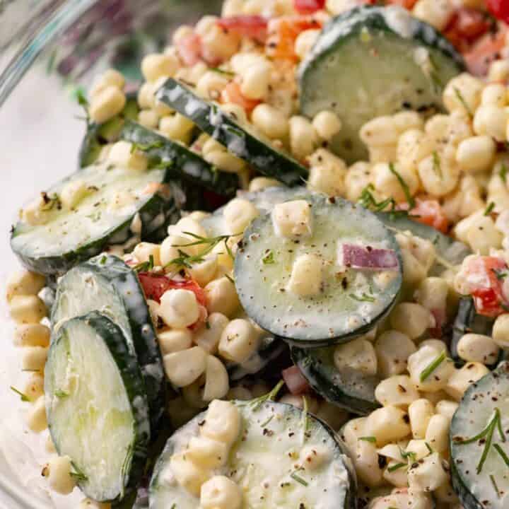 A glass bowl of corn and cucumber salad