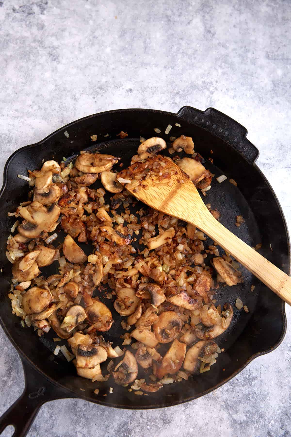 Onions and mushrooms in a skillet.