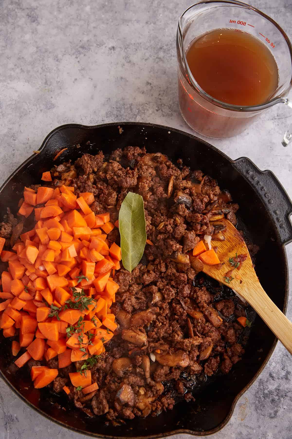 Carrots added to a skillet with ground beef.