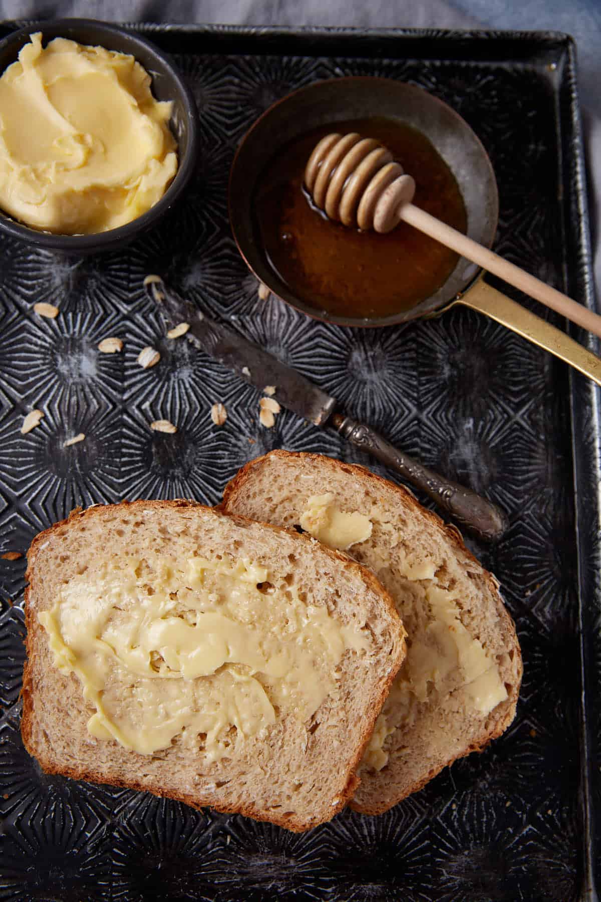 Slices of honey oatmeal bread on a tray.
