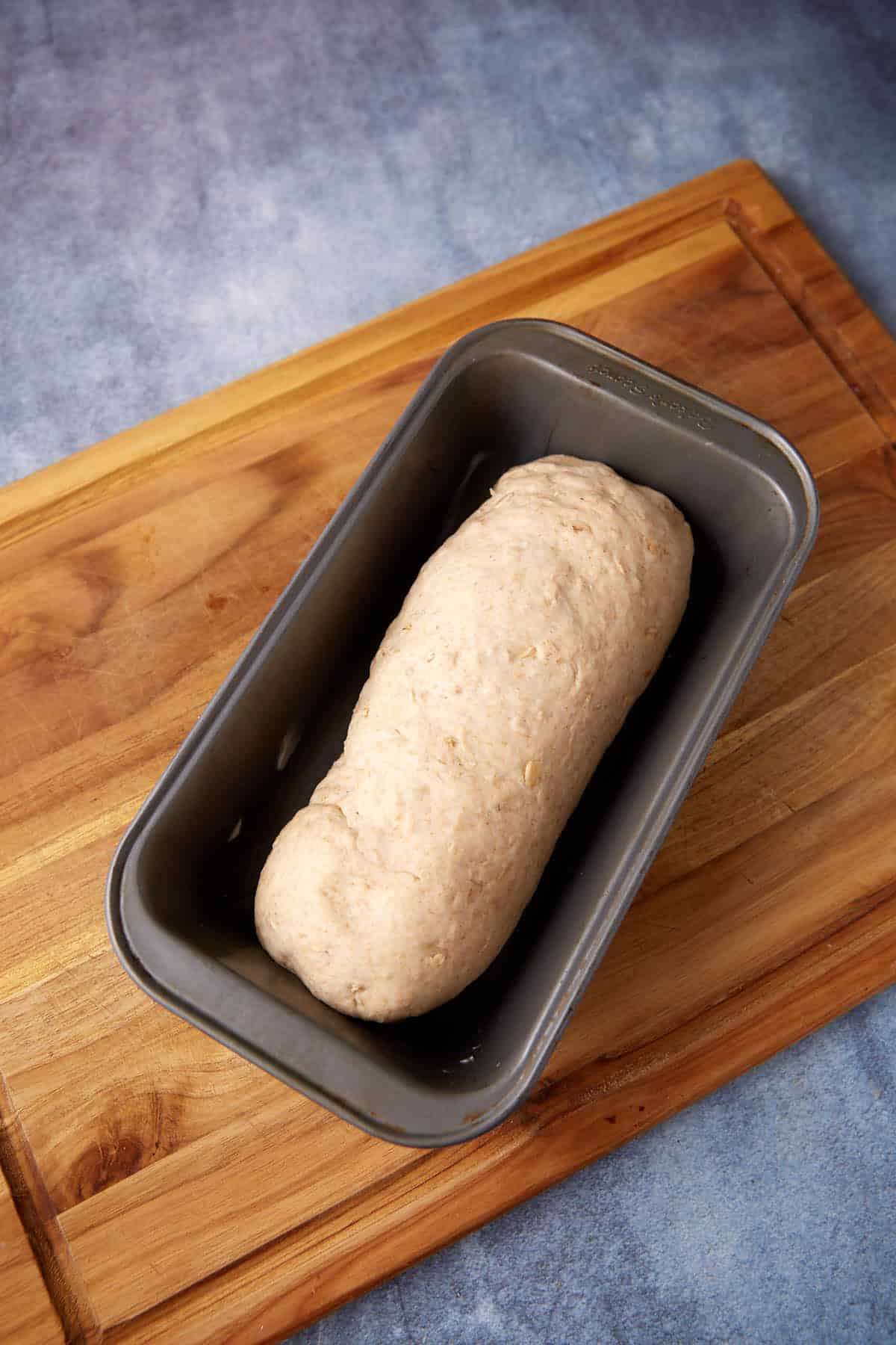The dough for oatmeal bread in a loaf pan,