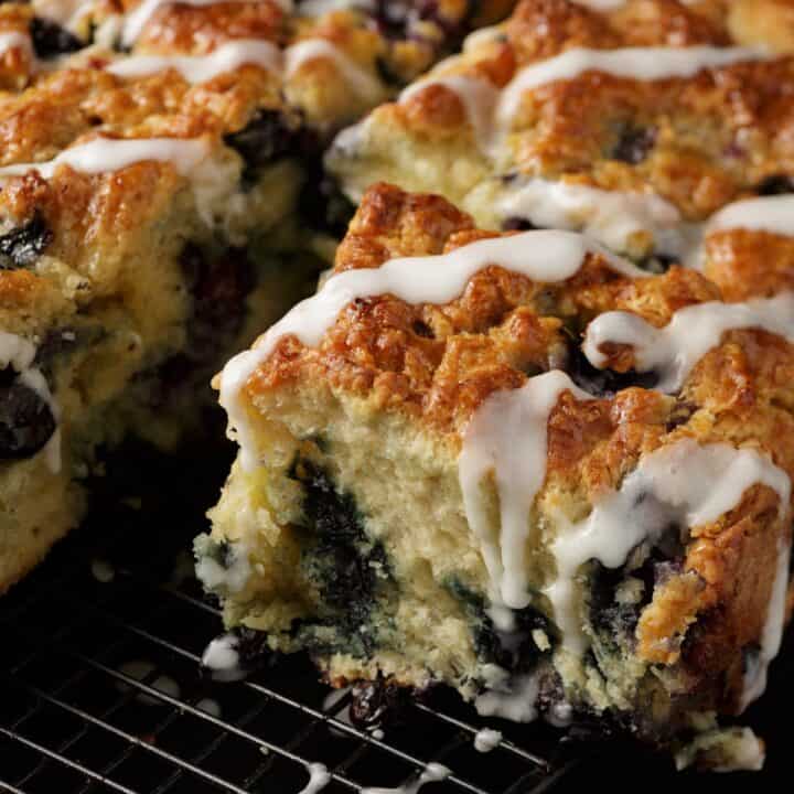 A Southern blueberry biscuit with a glaze dripping down the side.