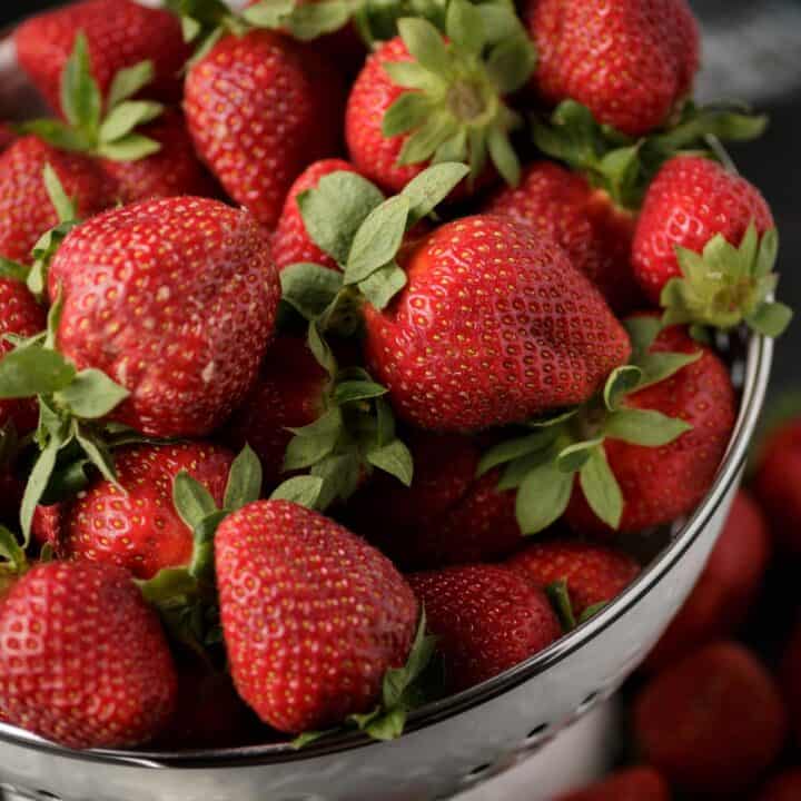 A colander of fresh picked strawberries.