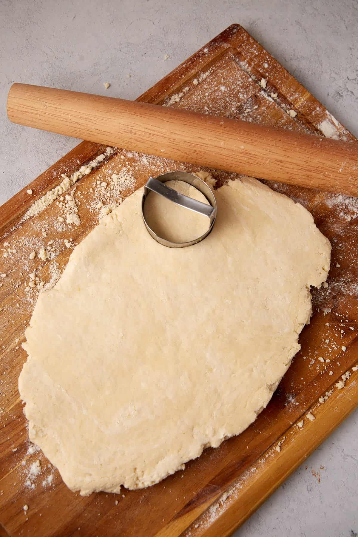 A biscuit cutter on rolled out biscuit dough.