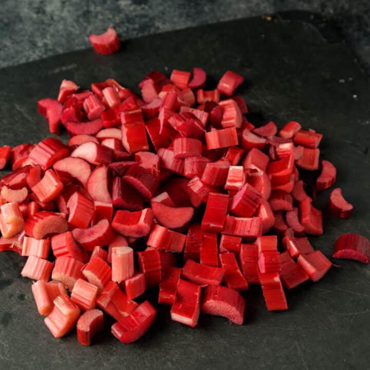 A cutting board topped with chopped fresh rhubarb.