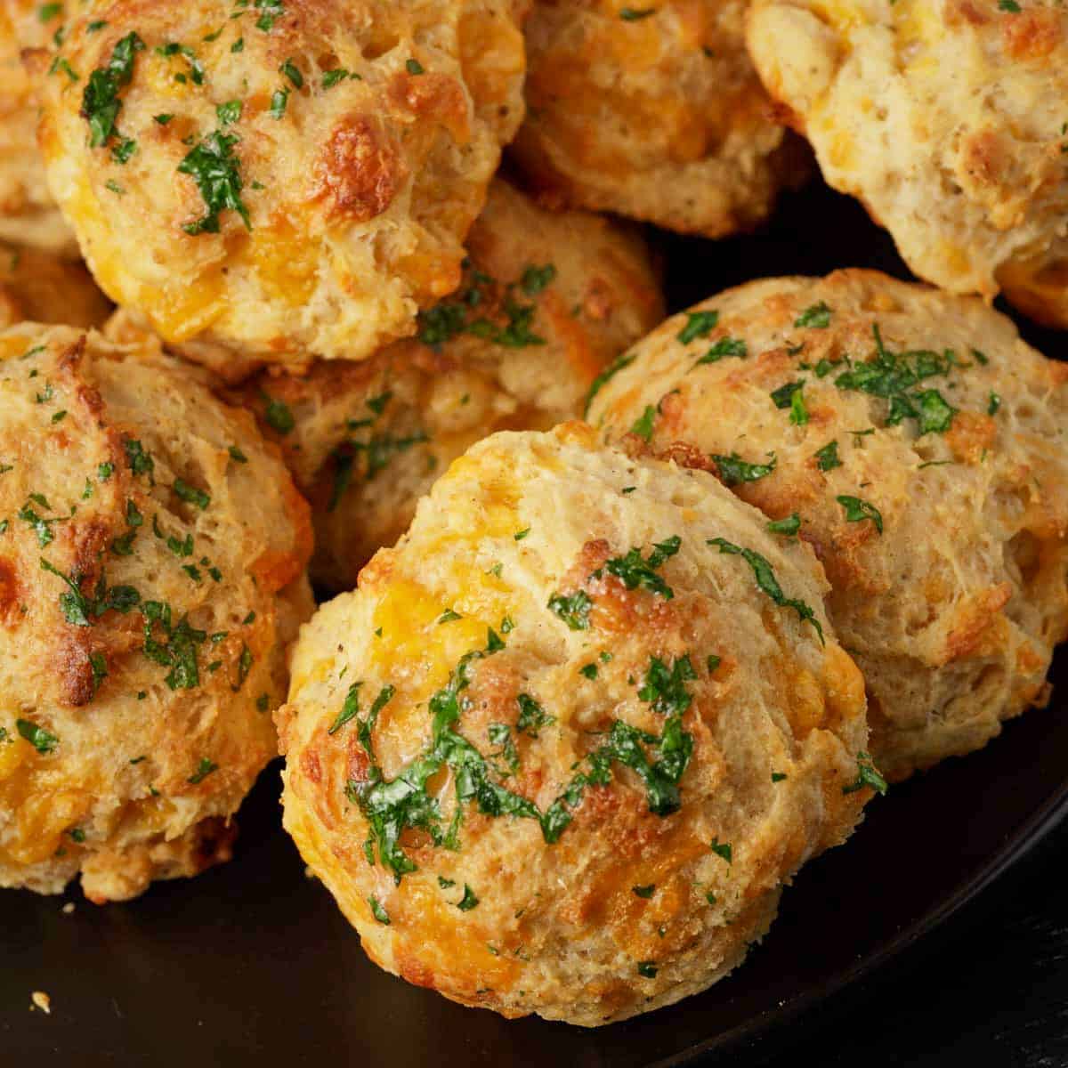 Cheddar bay biscuits stacked on a platter.