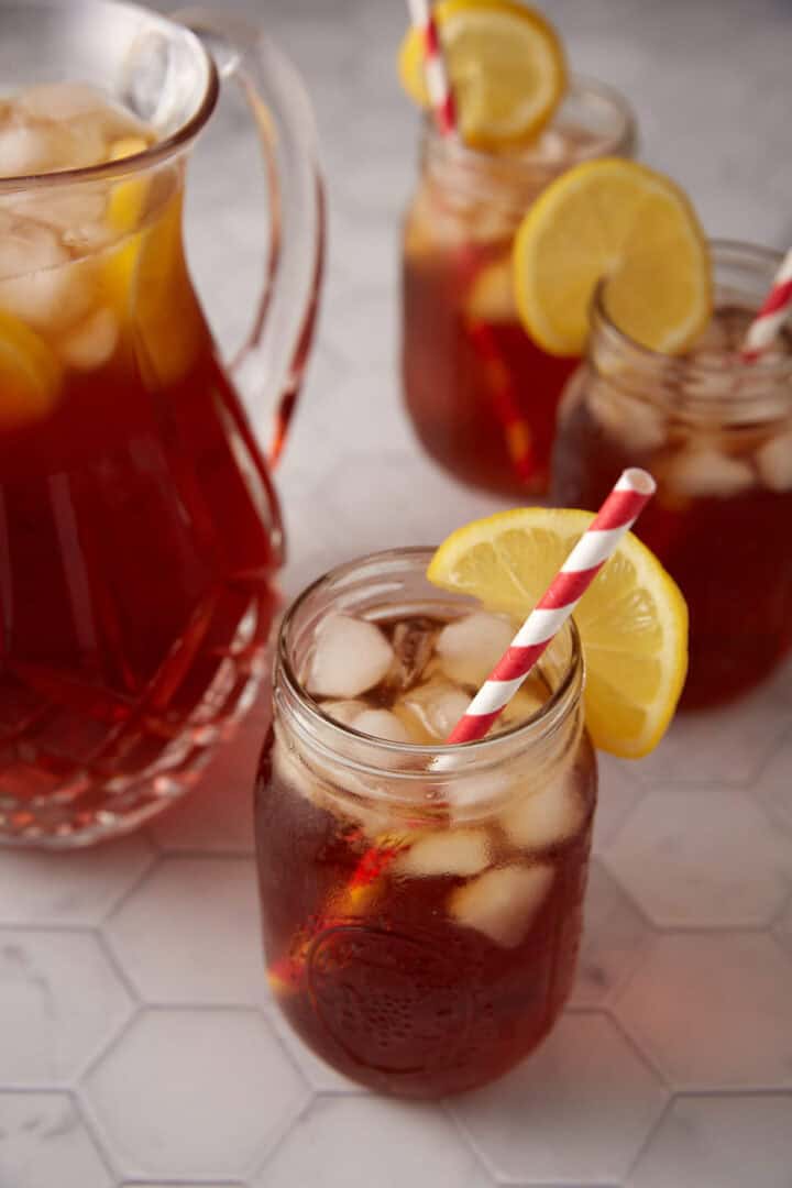 A pitcher with glasses of sweet iced tea.