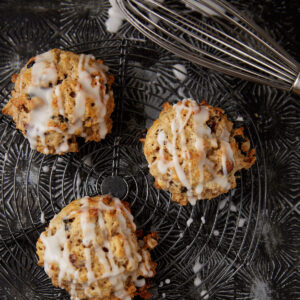 Three oatmeal scones next to a whisk.