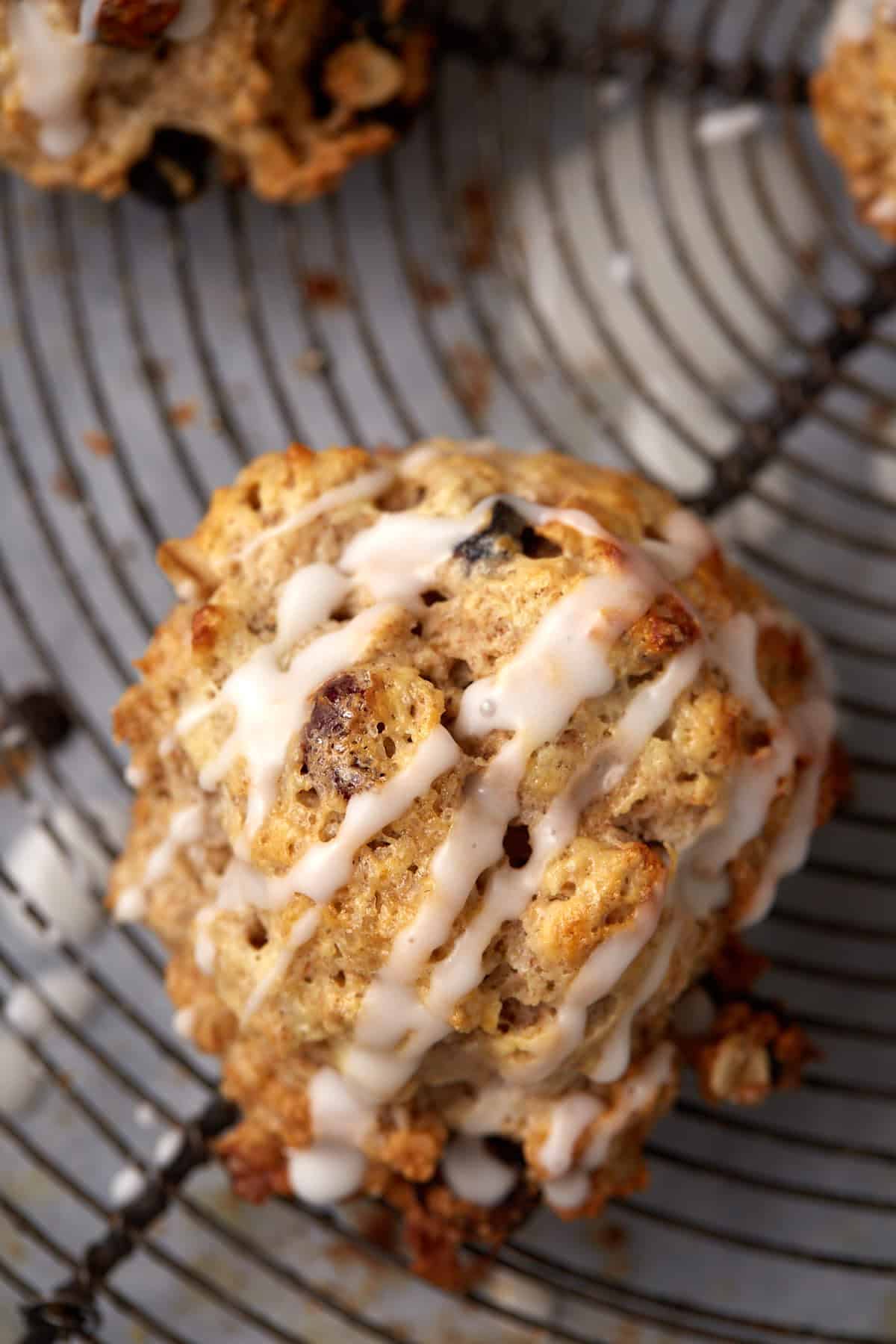 A single oatmeal scone drizzled with a glaze.