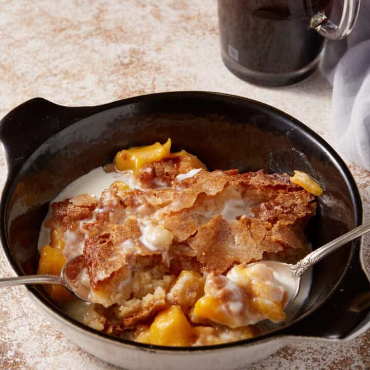 A serving of peach cobbler with two spoons.