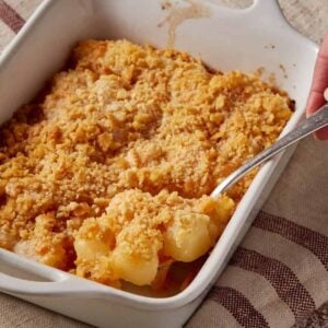 A spoon full of pineapple cheese casserole.