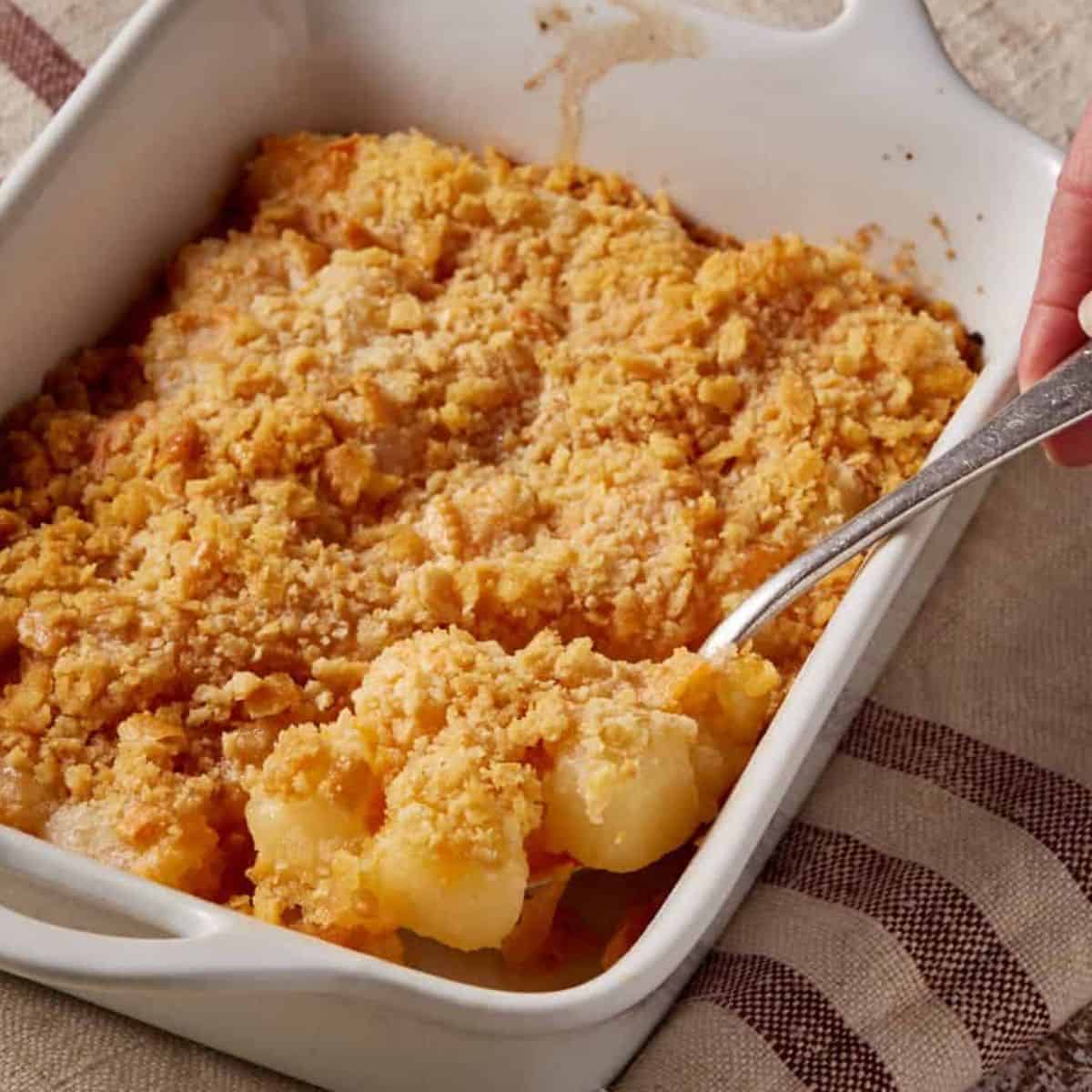 A spoon full of pineapple cheese casserole.