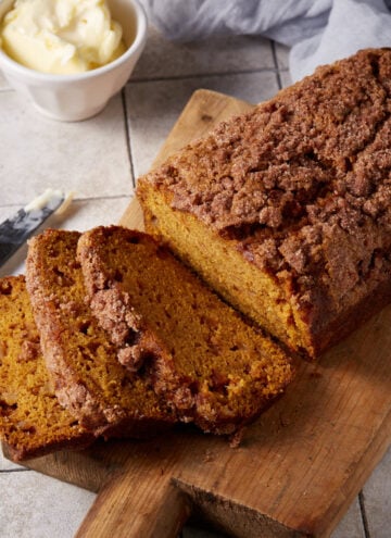 Pumpkin apple bread sliced on a cutting board.