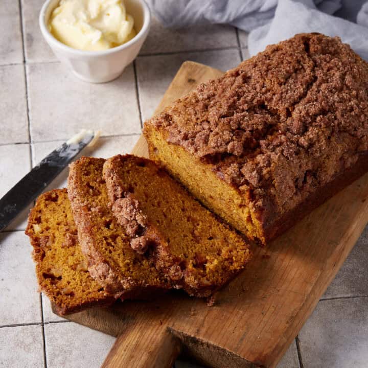 Pumpkin apple bread sliced on a cutting board.