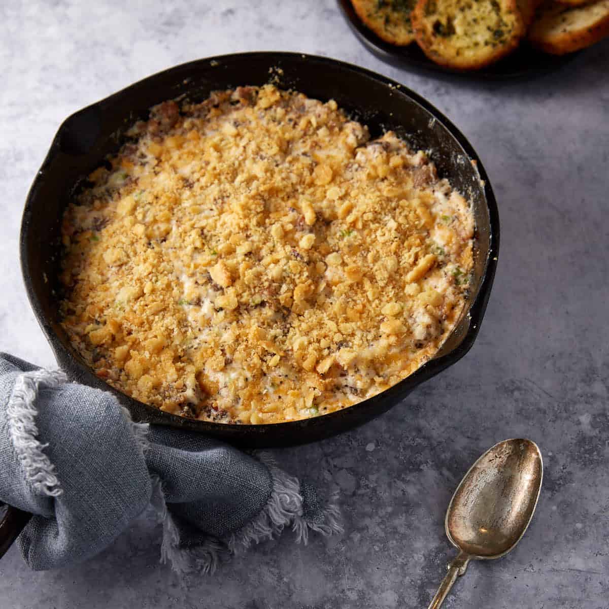 An iron skillet filled with cheesy bacon dip.