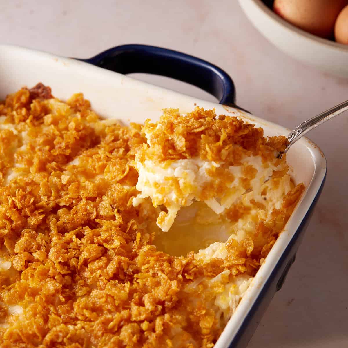 A spoon full of hashbrown casserole.