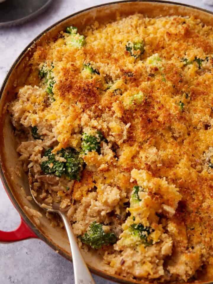 A skillet of broccoli rice casserole with a serving spoon.