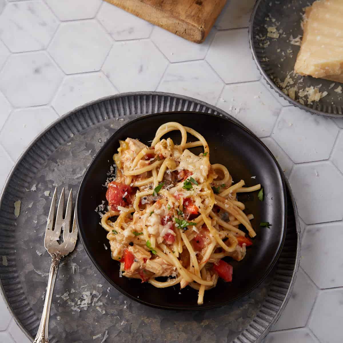 A plate of chicken spaghetti with slices of bread.