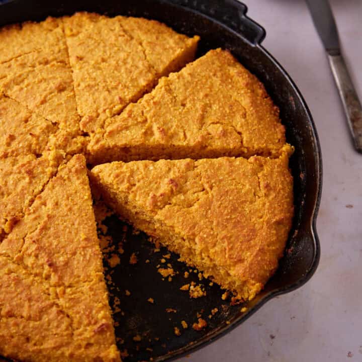 Sweet potato cornbread cut in a skillet.