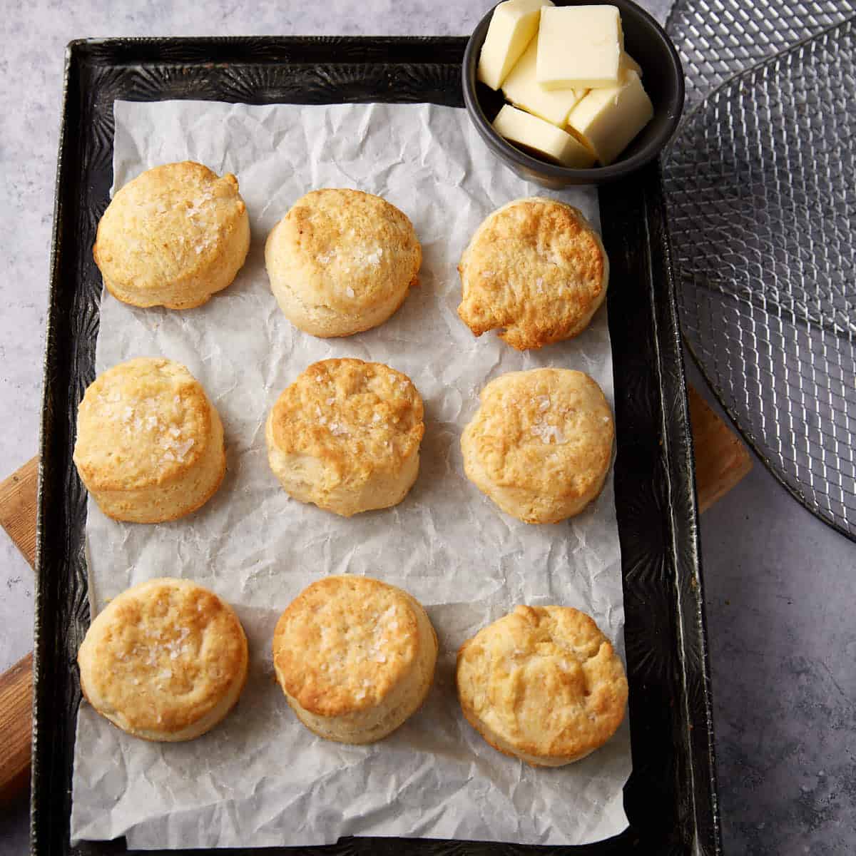 A batch of air fryer biscuits on parchment paper.