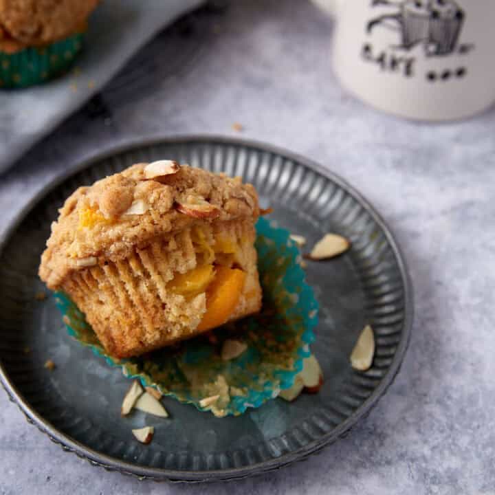 A peach muffin on a plate.