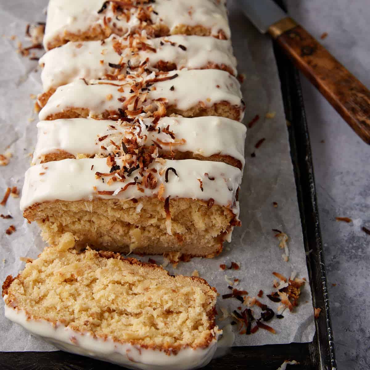 Sliced frosted pineapple bread on a tray.