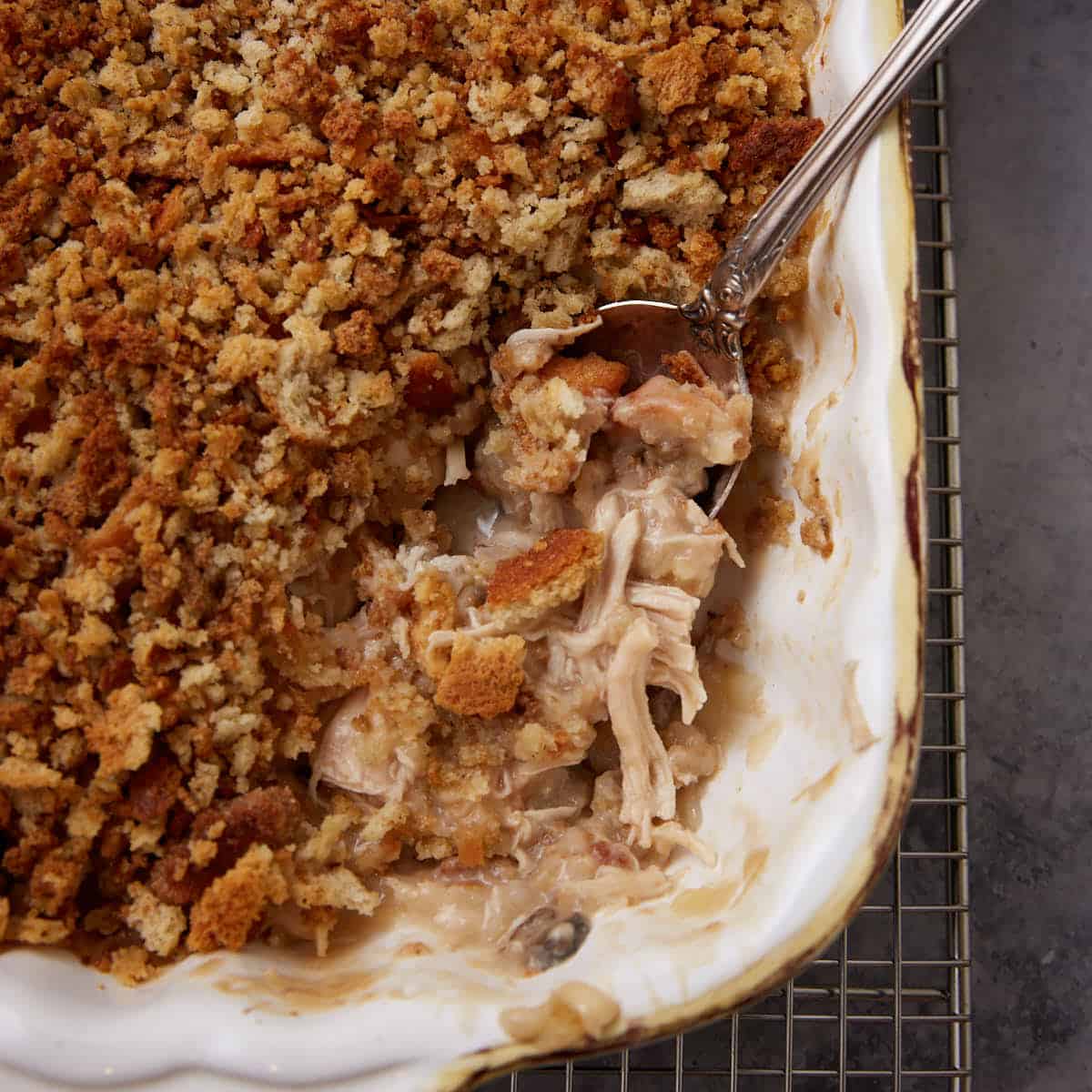 A chicken casserole with stuffing with a serving spoon.