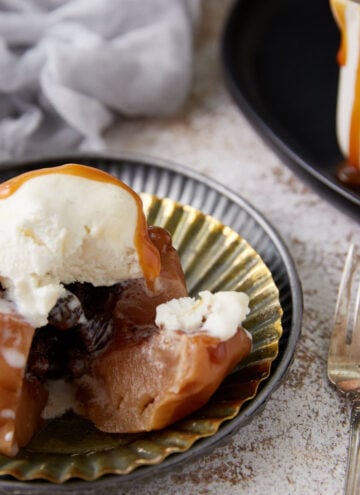 A single baked apple on a plate with a fork.