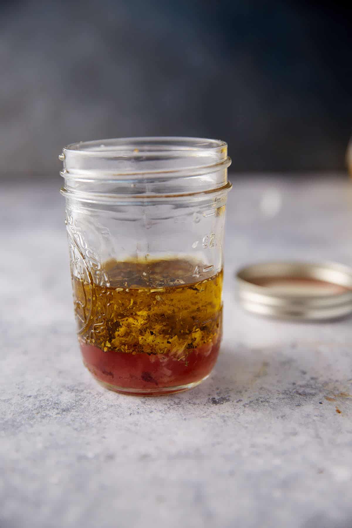 The ingredients for greek salad dressing in a jar.