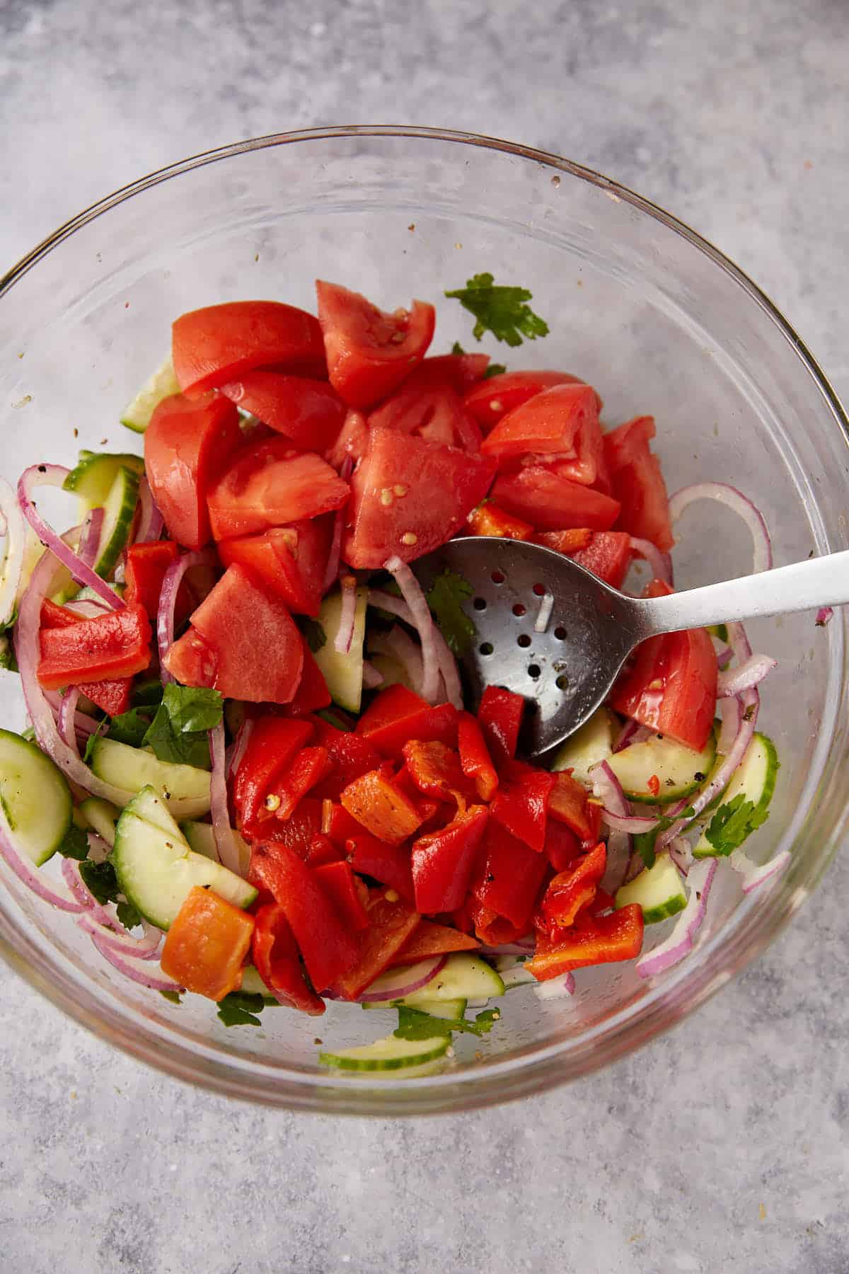 Tomates and red peppers added to a salad.